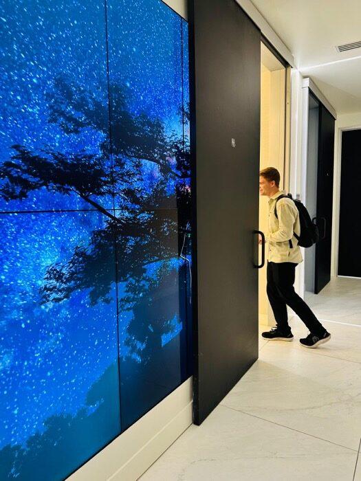 Elio Verhoef walking past a floor-to-ceiling video wall at Human Longevity's South San Francisco clinic